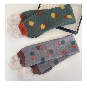 Dettaglio sciarpa a maglia per bambini con motivi a tulipano e doppi pompon