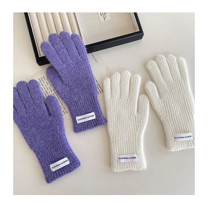 Detailed view of knitted winter gloves featuring ribbed texture and stylish fabric labels