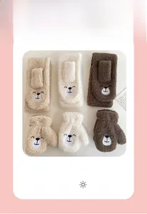 Detail of warm winter plush scarf and gloves set with cute bear embroidery for kids