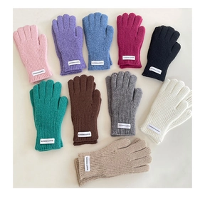 Detailed view of colorful knit gloves with ribbed cuffs and decorative quality fabric label