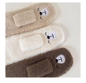 Close-up of cute bear embroidery on warm lamb wool scarf set in earthy brown colors