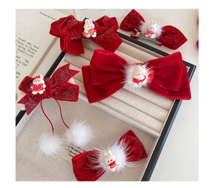 Detailed view of red velvet bow hairpins with cute rabbit charms and white fur pom-poms