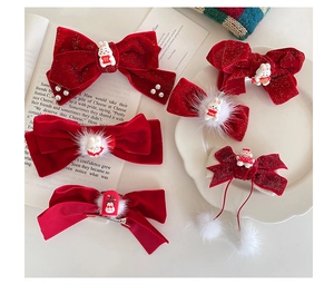 Close-up of velvet bow hair clips with white fur balls and golden Chinese New Year charms