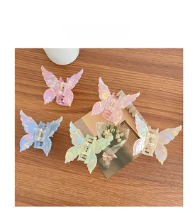 Détail de cinq pinces à cheveux papillon irisées de différentes couleurs sur bois
