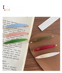 Set of colorful acetate hair clips with gold label on vintage book background