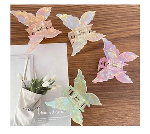 Pinces à cheveux papillon irisées aux tons pastels sur une table en bois rustique