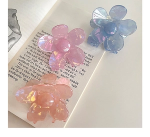 Détail de pinces à cheveux en acrylique translucide en forme de fleurs multicolores