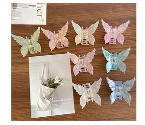 Gros plan de pinces à cheveux papillon aux couleurs pastel sur surface en bois