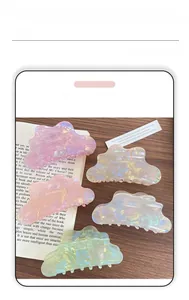 Detailed view of five colorful iridescent cloud hair claws on a rustic wooden table