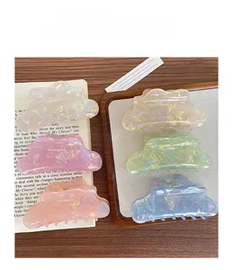 Set of five iridescent resin cloud-shaped hair claws in pastel colors on wooden tray