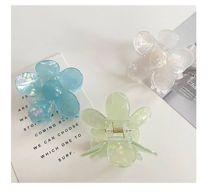 Détail des pinces à cheveux florales nacrées aux tons bleu, vert et blanc nacré