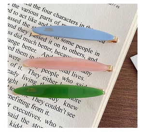 Detailed close-up of acetate hair clips in candy colors on a vintage book page