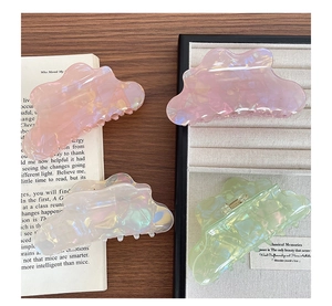 Detailed view of iridescent hair claws in pastel shades on a vintage background