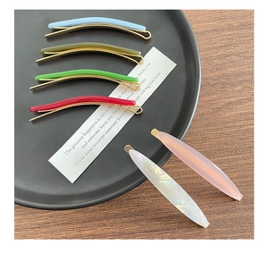 Close-up of colorful acetate hair clips and minimalist barrettes on a wooden surface