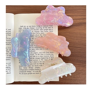 Iridescent cloud-shaped acetate hair claws in pastel colors on a vintage book