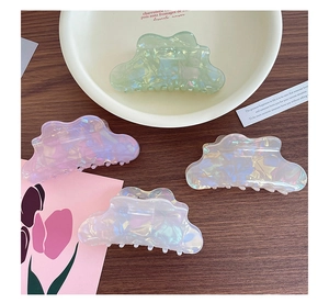 Close-up of cloud-shaped iridescent hair clips with pearlescent marble texture