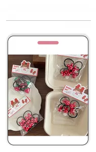 Detailed set of kids red polka dot rabbit ears and strawberry hair ties in packaging