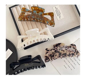 Set of four large acetate hair claws in amber, pearl white, leopard, and black finishes
