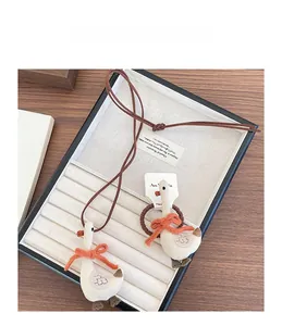 Close-up of cute fabric goose pendant necklace and hair tie set in a luxury jewelry box