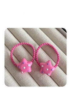 Dettaglio di elastici per capelli a stella rosa con pois viola e cordini