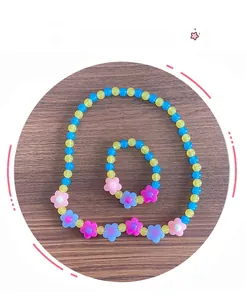 Dettaglio di un set di gioielli per bambini con perline in acrilico e fiori colorati