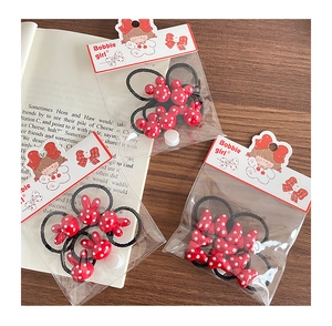 Close-up of red polka dot hair ties set with bunny ears and bows on a wooden table