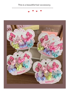 Dettaglio di elastici per capelli dai colori macaron con motivi a stelle e fiocchi