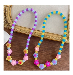 Dettaglio di collane con perline a fiori colorati in acrilico per bambine su vassoio