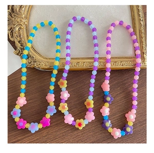 Dettaglio di collane con perline in acrilico colorato e fiori per bambine e regali