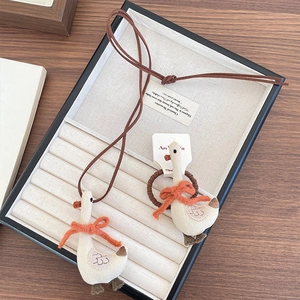 Handmade fabric goose necklace and hair tie set with orange bow in a beige jewelry box
