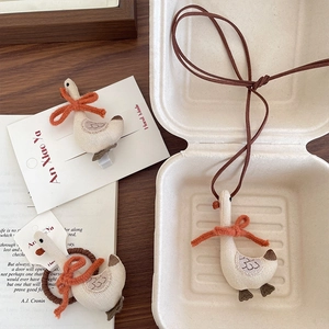 Handmade fabric goose accessories set including hair clip and necklace on wooden desk