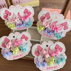 Set elastici capelli bimba con fiocchi e stelle colorate su scheda in legno