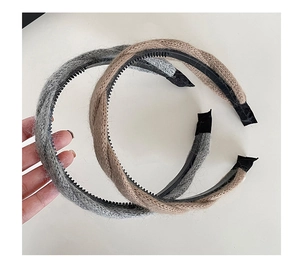 Détail d'un serre-tête tricoté torsadé avec dents antidérapantes en gris et café clair