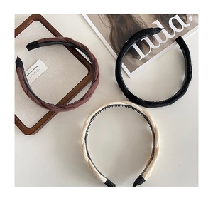 Détail de serre-têtes en maille torsadée noire, marron et beige avec dents antidérapantes