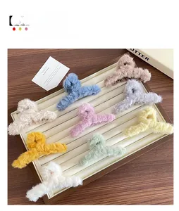 Vue détaillée de neuf pinces à cheveux en peluche colorées dans un plateau en bois