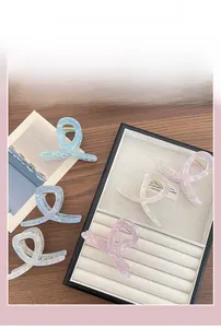 Dettaglio di pinze per capelli traslucide in colori macaron su un vassoio per gioielli