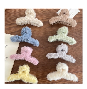 Lot de huit pinces à cheveux en peluche colorées disposées sur une surface en bois rustique