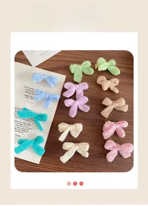 Close-up of colorful knitted bow hair clips set on a vintage book and wooden surface