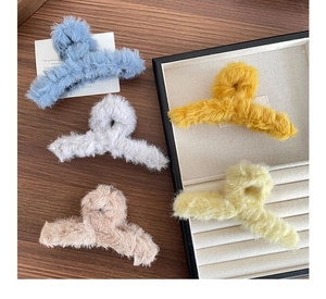 Détail de grandes pinces à cheveux en peluche de cinq couleurs sur bois chaleureux