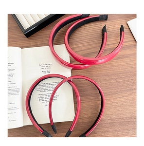 Detailed close-up of thick red faux leather headbands arranged on a rustic wooden desk