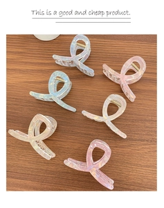 Dettaglio di 6 fermagli per capelli in acrilico cangiante in vari colori su legno scuro