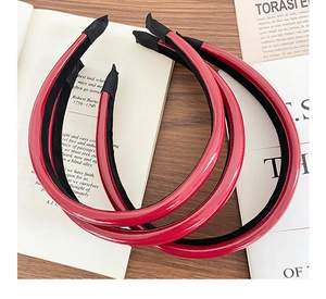 Detail view of red faux leather headbands with non-slip velvet lining on vintage books