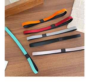 Close-up of five colorful elastic non-slip sports headbands on a wooden table surface