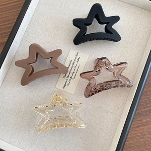 Set of four matte and transparent star-shaped hair claws in black, brown, and clear resin