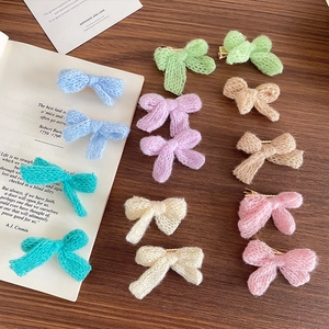 Macaron color knitted bow hair clips in various sweet candy tones on a wooden surface