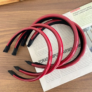 Three glossy red PU leather headbands on a vintage newspaper background for women