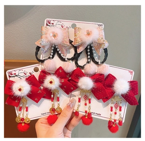 Detail von handgefertigten chinesischen Haarspangen mit rosa Bändern und roten Quasten