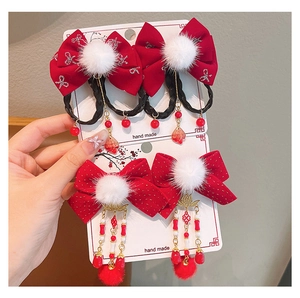 Detail eines roten Neujahrs-Haarclip-Sets mit Kunstfellbällen und langen Quasten