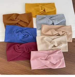 Flat lay detail of eight ribbed cotton twisted headbands in various solid colors