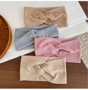 Flat lay of four ribbed cotton yoga headbands in camel, grey, pink, and beige tones